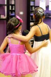 backside view of two little girls wearing dance costumes